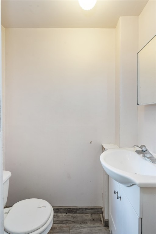 bathroom featuring vanity, hardwood / wood-style floors, and toilet