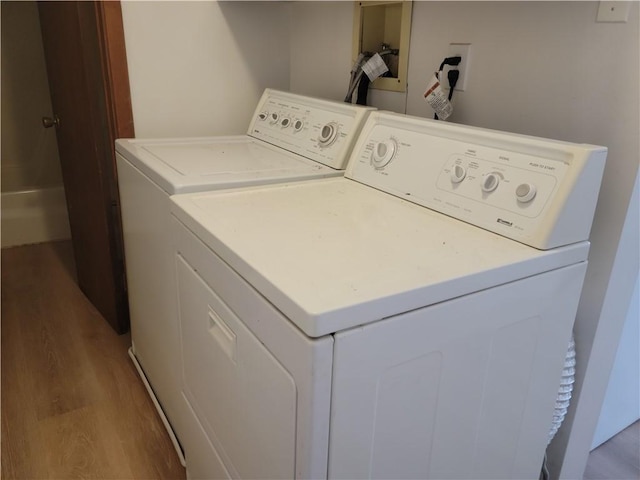 laundry area with washer and dryer and light hardwood / wood-style floors