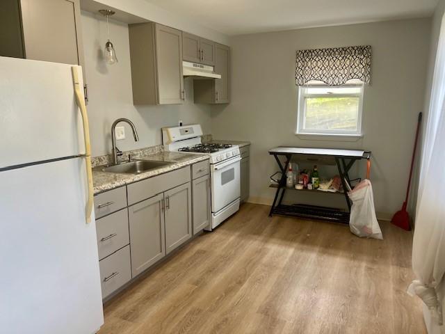 kitchen with decorative light fixtures, gray cabinets, white appliances, and sink