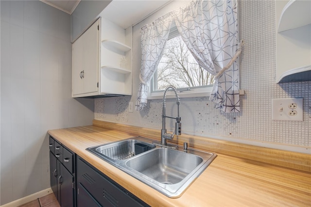 kitchen featuring tile flooring, sink, and ornamental molding