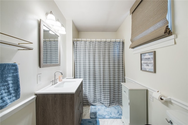 bathroom with tile flooring, toilet, and vanity with extensive cabinet space