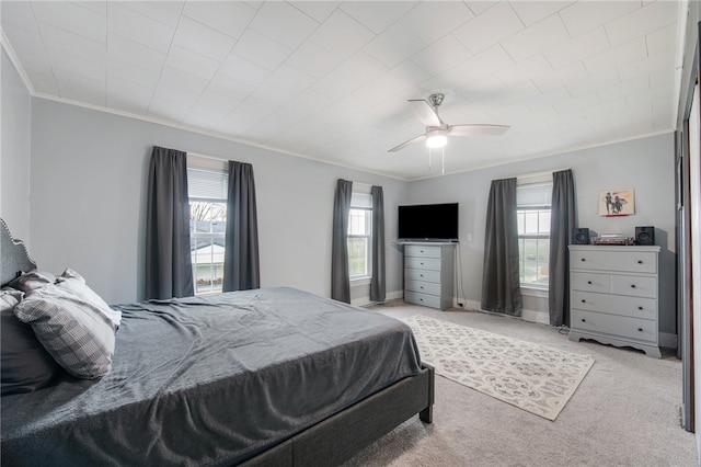 carpeted bedroom featuring ceiling fan, crown molding, and multiple windows