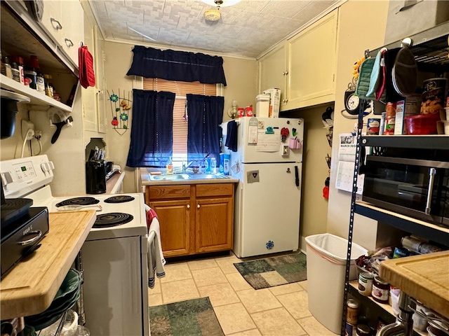 kitchen featuring light tile flooring, sink, and white appliances