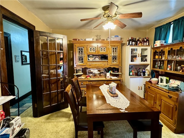 carpeted dining room featuring ceiling fan