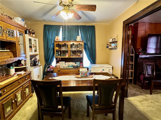 dining room featuring ceiling fan and dark carpet