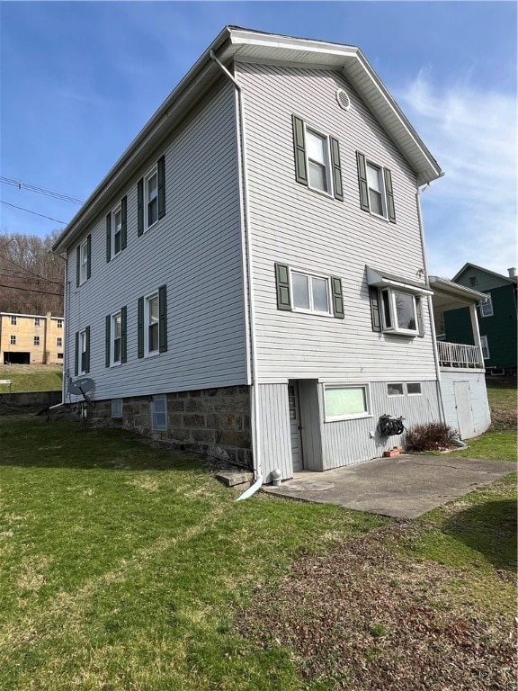 rear view of property with a lawn and a patio