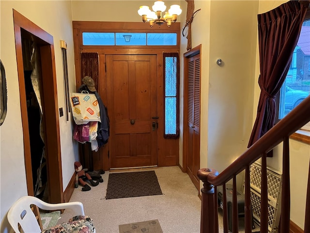 carpeted foyer featuring plenty of natural light and a chandelier