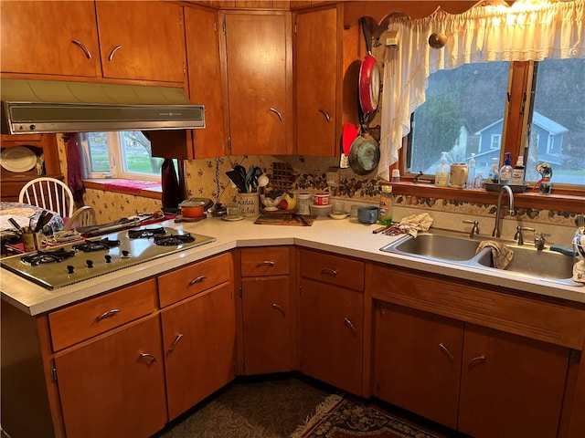 kitchen with backsplash, stainless steel gas stovetop, custom range hood, and sink