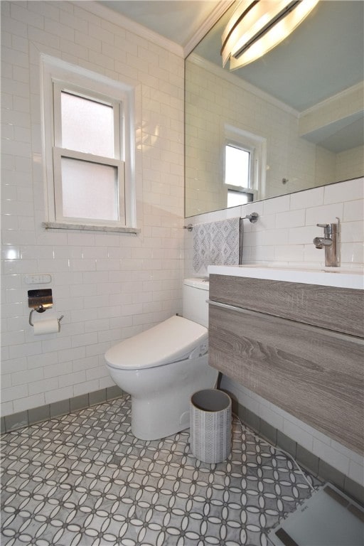 bathroom with vanity, toilet, tile walls, and crown molding