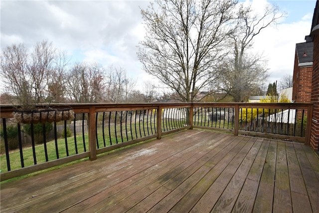 wooden terrace featuring a lawn