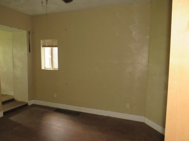 unfurnished room with dark wood-type flooring and ceiling fan