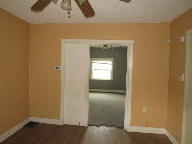 empty room with dark carpet and ceiling fan