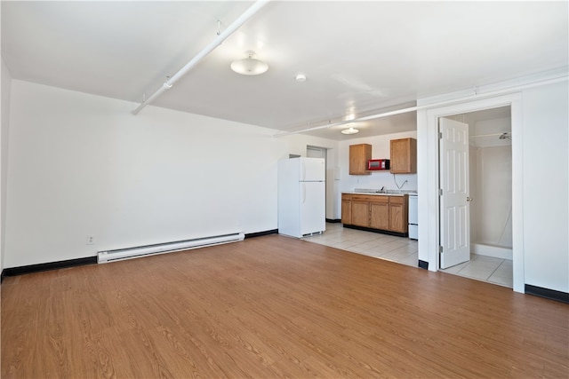 unfurnished living room featuring light hardwood / wood-style floors and a baseboard radiator