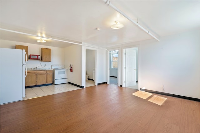 interior space featuring track lighting, sink, and light wood-type flooring