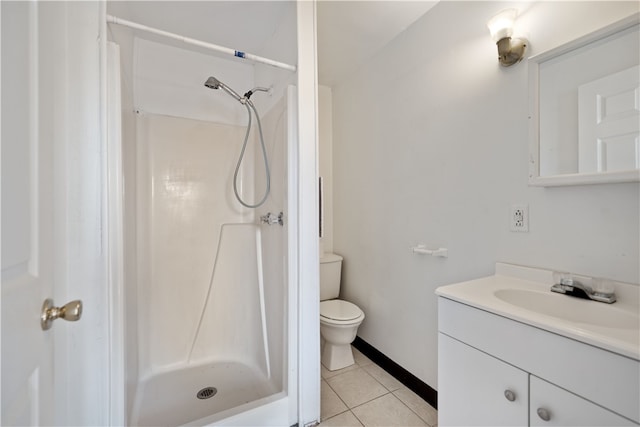 bathroom with tile flooring, a shower, vanity with extensive cabinet space, and toilet