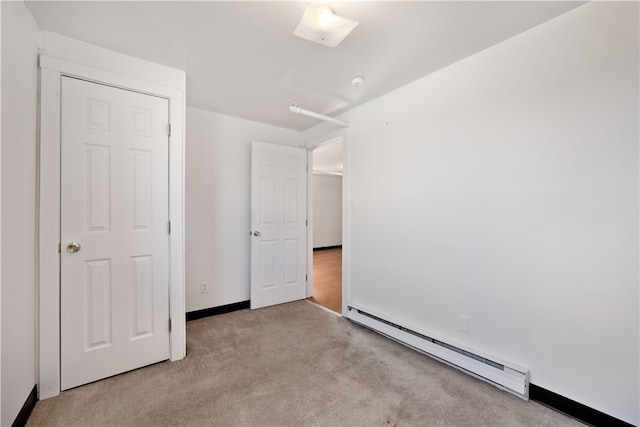 unfurnished bedroom with a closet, light carpet, and a baseboard radiator