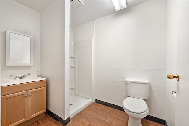 bathroom featuring a shower, toilet, wood-type flooring, and vanity