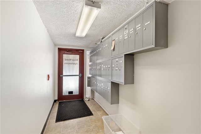 doorway with mail boxes, a textured ceiling, and light tile flooring