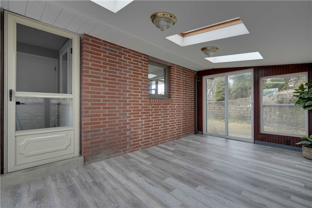 unfurnished sunroom with lofted ceiling with skylight