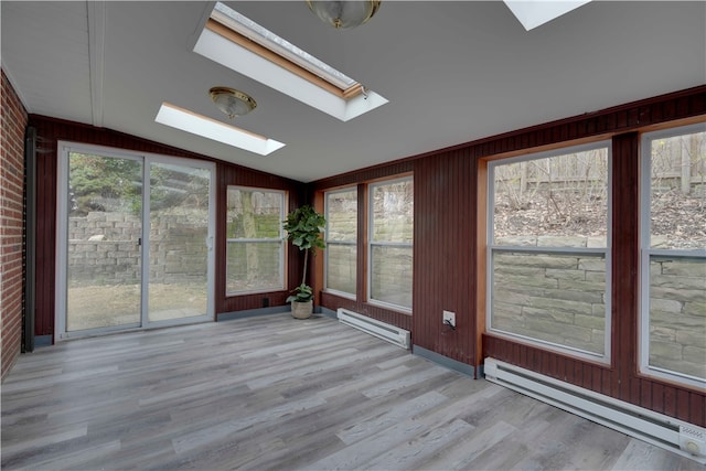 unfurnished sunroom with lofted ceiling with skylight, plenty of natural light, and a baseboard radiator