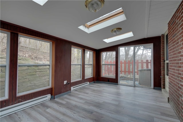 unfurnished sunroom with a baseboard radiator and vaulted ceiling with skylight