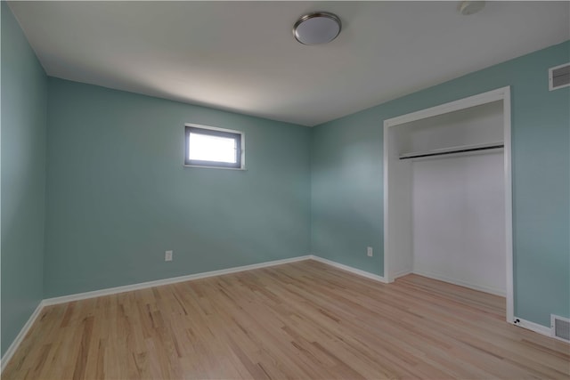 unfurnished bedroom featuring a closet and light wood-type flooring