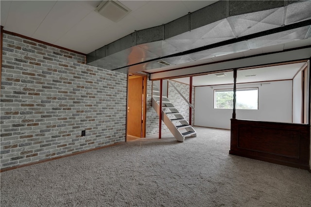 basement featuring carpet and brick wall