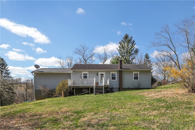 rear view of property with a wooden deck and a yard