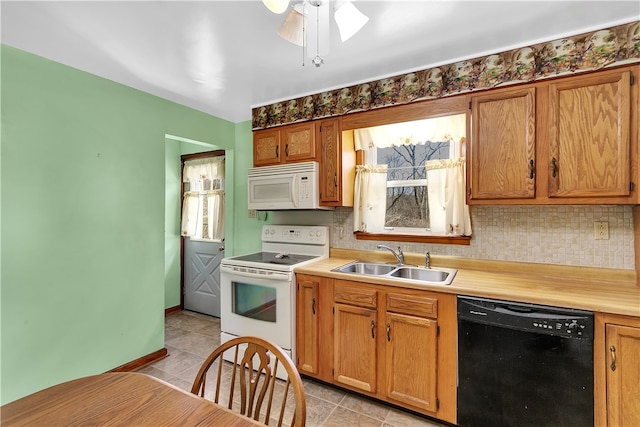 kitchen featuring ceiling fan, sink, white appliances, and plenty of natural light