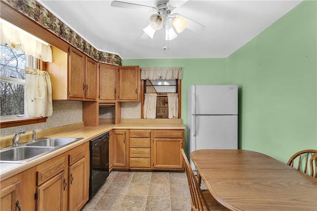 kitchen featuring white fridge, black dishwasher, ceiling fan, tasteful backsplash, and sink