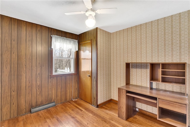 interior space featuring wood walls, ceiling fan, and light hardwood / wood-style flooring