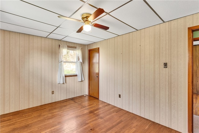 spare room with a paneled ceiling, light hardwood / wood-style floors, and ceiling fan