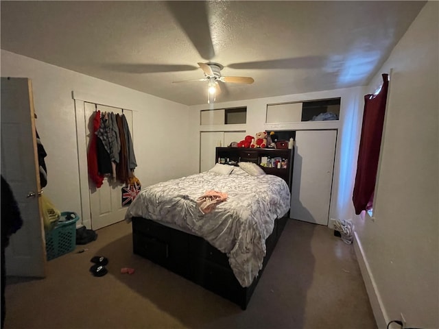 bedroom with ceiling fan, carpet floors, and two closets