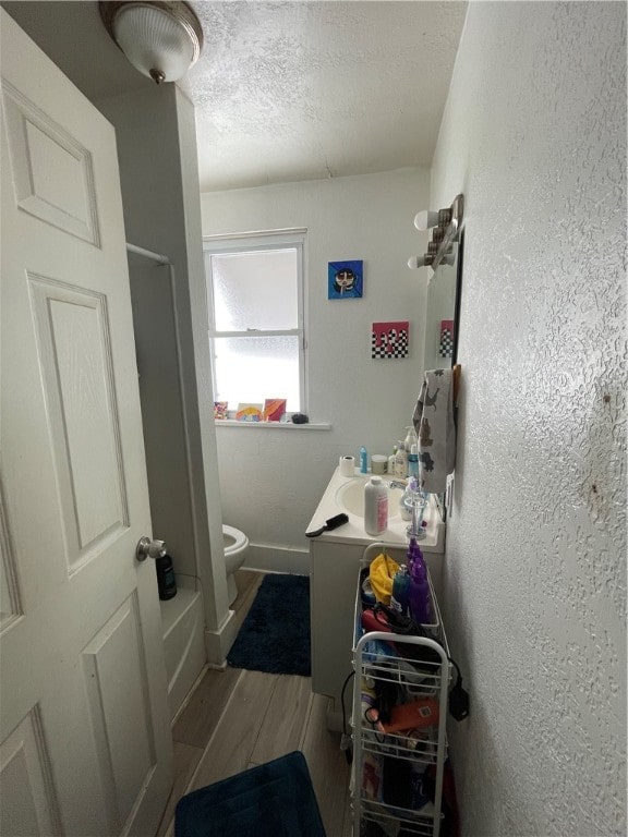 full bathroom with vanity, hardwood / wood-style flooring, toilet, a textured ceiling, and independent shower and bath