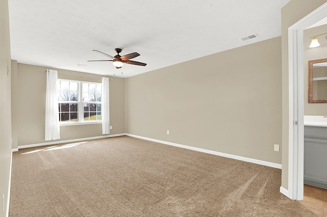 spare room featuring light carpet and ceiling fan