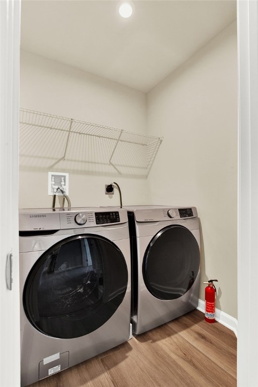 clothes washing area featuring light hardwood / wood-style floors and independent washer and dryer