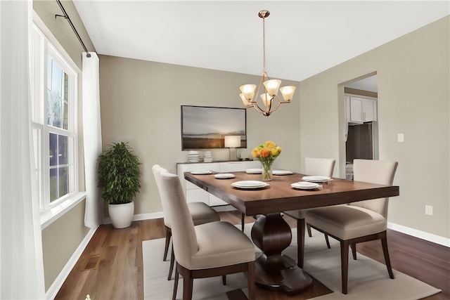 dining space with hardwood / wood-style flooring and a chandelier