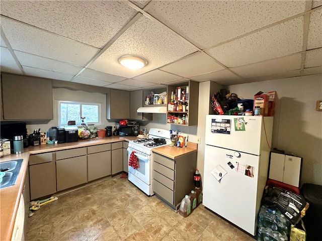 kitchen featuring a paneled ceiling, light tile floors, gray cabinets, and white appliances