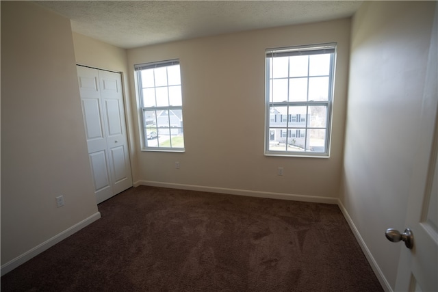 carpeted empty room with a textured ceiling