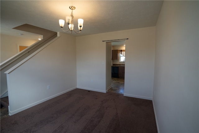 carpeted empty room with a notable chandelier