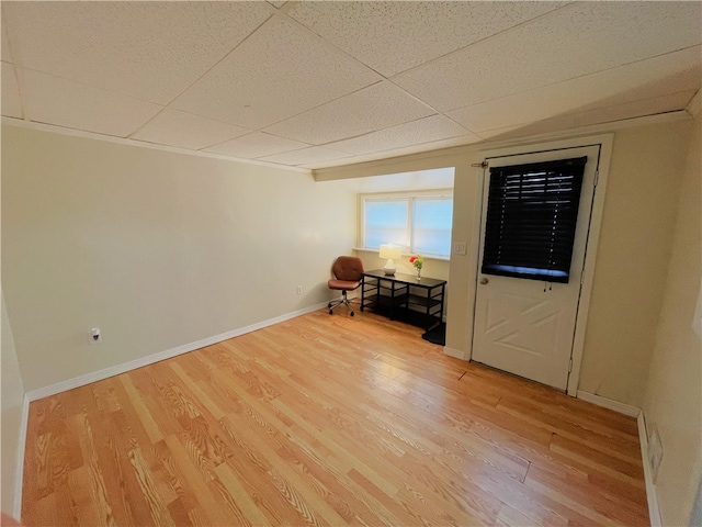 unfurnished bedroom with a drop ceiling and light hardwood / wood-style floors