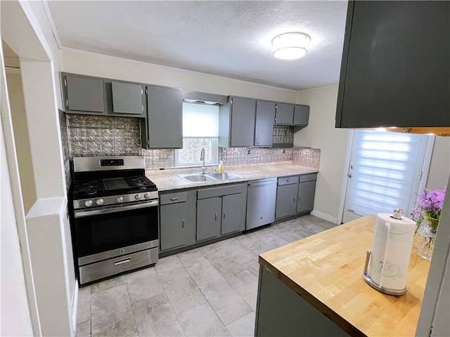 kitchen with stainless steel appliances, light tile flooring, tasteful backsplash, gray cabinetry, and sink