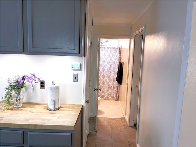 hallway with dark tile flooring and crown molding