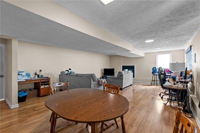 dining area with a textured ceiling and light wood-type flooring