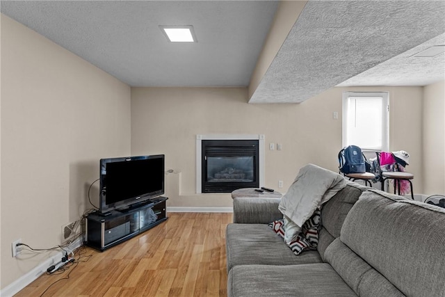 living room featuring wood-type flooring and a textured ceiling