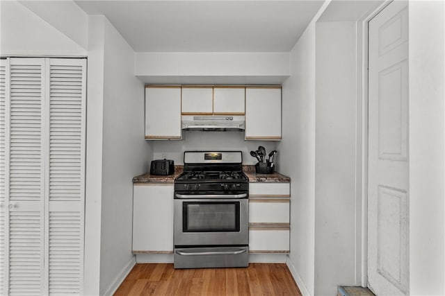 kitchen featuring white cabinets, light wood-type flooring, and stainless steel gas stove