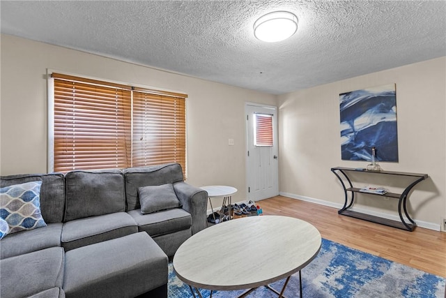 living room with a textured ceiling and light wood-type flooring