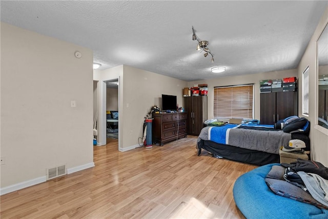 bedroom with light hardwood / wood-style flooring and a textured ceiling