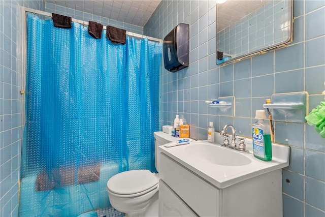 full bathroom featuring shower / tub combo with curtain, vanity, toilet, and tile walls