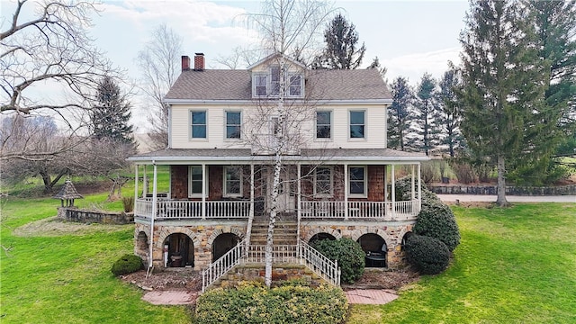 view of front of home with a front yard and covered porch